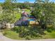 Aerial view of a blue home with well-kept lawn, mature trees, and a swimming pool in the backyard at 327 Se 50Th Ave, Ocala, FL 34471