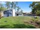 A large green lawn complements the blue home's exterior with a pool and spacious backyard at 327 Se 50Th Ave, Ocala, FL 34471
