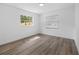 Sunlit bedroom with wood-look floors featuring a window overlooking the outdoors at 327 Se 50Th Ave, Ocala, FL 34471