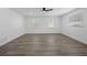 Spacious bedroom featuring three windows, ceiling fan, and wood-look flooring at 327 Se 50Th Ave, Ocala, FL 34471