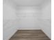 Walk-in closet with built-in white wire shelving and wood-look flooring at 327 Se 50Th Ave, Ocala, FL 34471