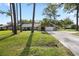 Blue home with stone facade, a long driveway, mature trees and green grass lawn at 327 Se 50Th Ave, Ocala, FL 34471