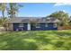 Blue home's rear exterior featuring a well maintained lawn at 327 Se 50Th Ave, Ocala, FL 34471