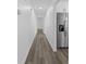 Hallway with gray wood-look flooring leads past stainless steel refrigerator at 327 Se 50Th Ave, Ocala, FL 34471