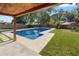 Covered patio with a pool, concrete deck, and green grass is perfect for outdoor relaxation and entertaining at 327 Se 50Th Ave, Ocala, FL 34471
