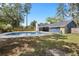 A private pool with a concrete deck is surrounded by a spacious backyard and tall trees in this home's exterior at 327 Se 50Th Ave, Ocala, FL 34471