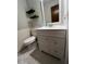 Bathroom featuring a white vanity, a toilet, decorative floating shelves, and updated fixtures at 3833 Ne 17Th Street Cir, Ocala, FL 34470