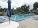 Inviting community pool with lounge chairs and umbrella for relaxation and enjoyment at 3856 Ne 17Th Street Cir, Ocala, FL 34470