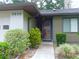 Well-lit entryway with shrubs leading to the home's front door at 3856 Ne 17Th Street Cir, Ocala, FL 34470