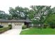 Charming single-story home with lush landscaping, a driveway, and an attached one car garage at 3856 Ne 17Th Street Cir, Ocala, FL 34470