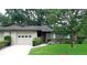 Charming single-story home with lush landscaping, a driveway, and an attached one car garage at 3856 Ne 17Th Street Cir, Ocala, FL 34470