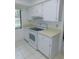 Kitchen features white appliances, cabinets, and tile flooring at 3856 Ne 17Th Street Cir, Ocala, FL 34470