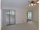 Bright living room boasting plush carpet, a ceiling fan, and dual sliding glass doors leading outside at 3856 Ne 17Th Street Cir, Ocala, FL 34470
