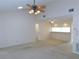 Open living room with a ceiling fan and bar top that looks into the kitchen area at 3856 Ne 17Th Street Cir, Ocala, FL 34470