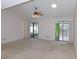 Expansive living room features neutral tones, vaulted ceilings, and slider door access to outside at 3856 Ne 17Th Street Cir, Ocala, FL 34470