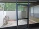 Screened patio with a view of a cozy outdoor area, enhancing the home's connection with nature at 3856 Ne 17Th Street Cir, Ocala, FL 34470