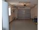 Garage featuring a gray roll-up door, water heater and overhead lighting at 3904 Ne 22Nd St, Ocala, FL 34470
