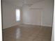 Spacious living room with tile flooring, ceiling fan, and access to the outdoors at 3904 Ne 22Nd St, Ocala, FL 34470