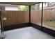View of the screened porch with neutral concrete flooring and a view of the backyard wood fence at 3904 Ne 22Nd St, Ocala, FL 34470