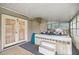 Enclosed sunroom with a hot tub, tiled surround, and outdoor access at 4025 Ne 18Th St, Ocala, FL 34470
