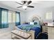 Cozy bedroom with queen bed, gray headboard, wood nightstands, plantation shutters, and a ceiling fan at 4258 Sw Zinnia Ct, Dunnellon, FL 34431