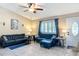 Cozy living room featuring tile flooring, plantation shutters, and comfortable blue furnishings at 4258 Sw Zinnia Ct, Dunnellon, FL 34431