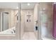 Modern bathroom featuring glass-enclosed shower, soaking tub, and neutral tile at 4465 Se 48Th Place Rd, Ocala, FL 34480