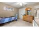 Bedroom with neutral walls and carpet, features a ceiling fan, window, and dresser at 4465 Se 48Th Place Rd, Ocala, FL 34480