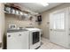 Well-equipped laundry room with modern washer, dryer, shelving, and convenient access door at 4465 Se 48Th Place Rd, Ocala, FL 34480