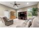 Comfortable living room featuring plush seating, a ceiling fan, and natural light at 4465 Se 48Th Place Rd, Ocala, FL 34480