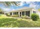 Exterior backyard view featuring lush green lawn, well-maintained landscaping, and white house facade at 5151 Sw 39Th St, Ocala, FL 34474