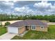 Single-story home featuring a two-car garage, a paved walkway, and a verdant, grassy lawn at 5331 Sw 121St Ter, Ocala, FL 34481