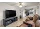 Open-concept living room with neutral tile flooring, ceiling fan, and access to the kitchen at 6127 Sw 84Th Place Rd, Ocala, FL 34476