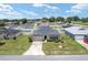 Aerial view of a single-story home with a gray roof, lush lawn, and a long driveway at 6646 Sw 64Th Ave, Ocala, FL 34476