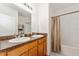 Bright bathroom with a double sink vanity, large mirror, and a shower-tub combo with tile flooring at 6646 Sw 64Th Ave, Ocala, FL 34476