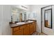 Well-lit bathroom featuring dual sinks, a large mirror, walk-in shower, and neutral accents at 6646 Sw 64Th Ave, Ocala, FL 34476