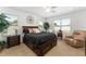 Well-lit bedroom with a dark wood bed set, side tables, and sitting chair at 6646 Sw 64Th Ave, Ocala, FL 34476