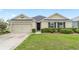 Inviting single-story home with a tidy front yard, two-car garage, and manicured hedges enhancing its curb appeal at 6646 Sw 64Th Ave, Ocala, FL 34476