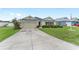 Charming single-story home with a long driveway, two-car garage, and manicured front yard featuring an American flag at 6646 Sw 64Th Ave, Ocala, FL 34476