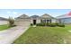 Attractive single-story home featuring a well-manicured lawn, two-car garage, and dark window shutters at 6646 Sw 64Th Ave, Ocala, FL 34476