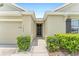 Welcoming front entrance with a pathway flanked by manicured bushes and pristine white rock landscaping, adjacent to a garage at 6646 Sw 64Th Ave, Ocala, FL 34476