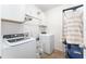 Efficient laundry room with a front load washer and dryer, upper cabinets, and practical organization at 6646 Sw 64Th Ave, Ocala, FL 34476