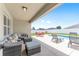 A covered patio offers an outdoor seating area overlooking the pool with lounge chairs and outdoor dining at 6646 Sw 64Th Ave, Ocala, FL 34476