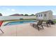 Backyard pool with lounge chairs, shed, and white vinyl fence for privacy at 6646 Sw 64Th Ave, Ocala, FL 34476
