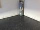 View of a water heater in a garage with a speckled dark epoxy floor and white walls at 6646 Sw 64Th Ave, Ocala, FL 34476