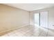 A bedroom with neutral walls, tile flooring, and sliding glass door to sunroom at 70 Sapphire Rd, Ocala, FL 34472