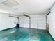 Clean garage featuring a painted floor, white walls, garage door mechanism, and ample space for parking and storage solutions at 70 Sapphire Rd, Ocala, FL 34472