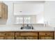 Kitchen sink with bright countertops and wood cabinets, connecting seamlessly with the spacious living area at 70 Sapphire Rd, Ocala, FL 34472