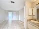 Versatile living space with tile floors, sliding glass door, and a vanity area near the entrance at 70 Sapphire Rd, Ocala, FL 34472