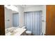 Bright bathroom featuring a vanity with a white countertop and a shower/tub with a blue floral curtain at 8205 Sw 100Th Lane Rd, Ocala, FL 34481